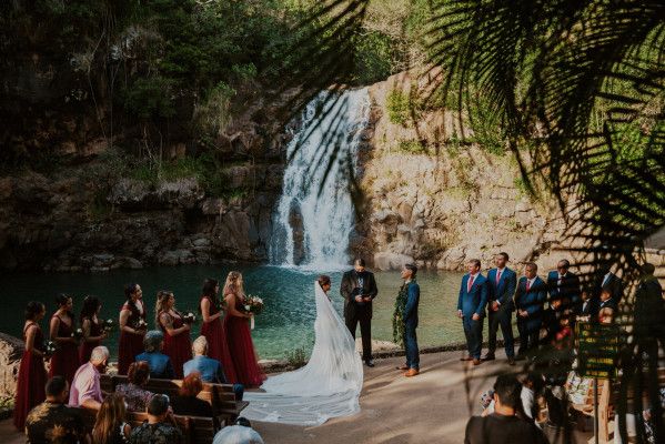 Couple getting married in Hawaii with a waterfall in the background